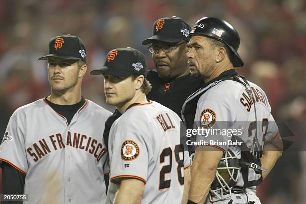 Second baseman Jeff Kent, David Bell, manager Dusty Baker and catcher Benito Santiago of the San Francisco Giants against look on during game two of...