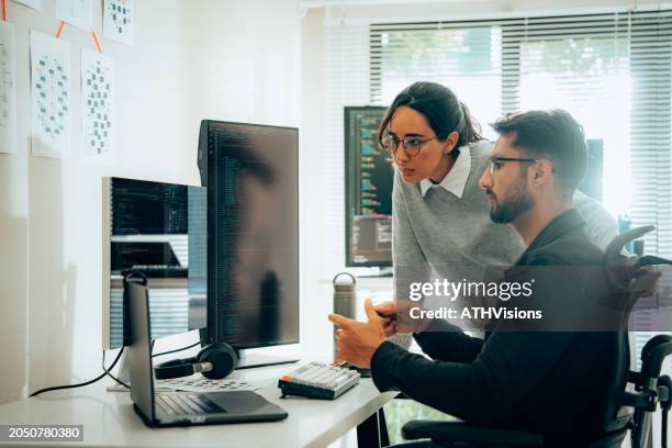 programmatori ispanici che collaborano allo sviluppo di software in un ambiente d'ufficio moderno - programmazione televisiva foto e immagini stock