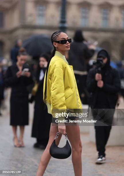 Fashion Week Guest is seen wearing a black bag, black shorts, a white top, dark dior shades and a yellow Off White jacket before the Off White...
