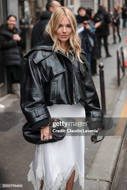 Sienna Miller wears black leather jacket, white satin skirt, black Chloe bag, outside Chloe, during the Womenswear Fall/Winter 2024/2025 as part of...