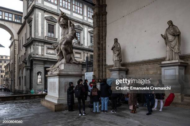People stand next to the marble statue The Rape of Polyxena by Italian sculptor Pio Fedi while visiting the Loggia dei Lanzi on March 01, 2024 in...