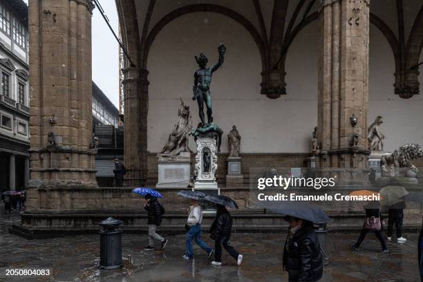 People walk past the bronze statue of Perseus with the Head of Medusa by Italian sculptor Benvenuto Cellini, displayed at Loggia dei Lanzi on March...