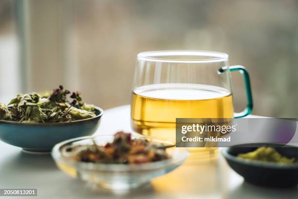 a cup of tea with dry fruit, flowers, and herbs. - herb stock pictures, royalty-free photos & images