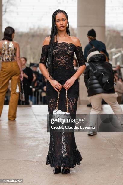 Jamilla Strand wears black lace long dress, silver Rabanne bag, outside Rabanne, during the Womenswear Fall/Winter 2024/2025 as part of Paris Fashion...