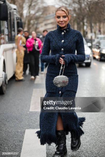 Veronica Ferraro wears blue long cardigan dress, silver Rabanne bag, black boots, outside Rabanne, during the Womenswear Fall/Winter 2024/2025 as...