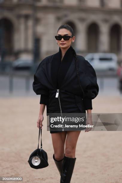 Pia Jauncey is seen wearing black leather high heels, black Off White shades, a black bag with a silver ornament on it and a fluffy black jacket...