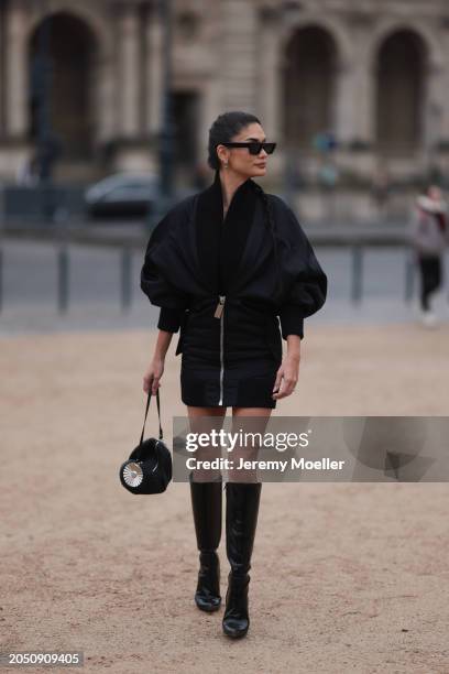 Pia Jauncey is seen wearing black leather high heels, black Off White shades, a black bag with a silver ornament on it and a fluffy black jacket...