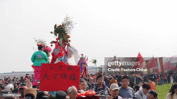 Children playing mythical figures are hoisted up in a "shehuo" parade, a traditional folk performance in a village in Xi'an in northwest China's...