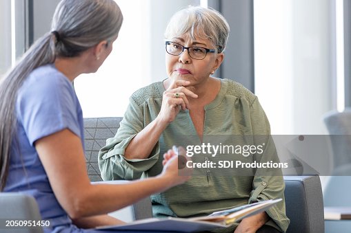 Una anciana escucha atentamente mientras la doctora explica el diagnóstico Una anciana escucha atentamente mientras la doctora explica el diagnóstico