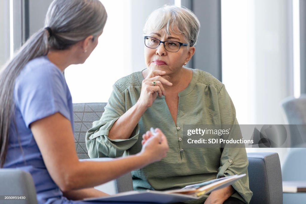 Senior woman listens carefully as female doctor explains diagnosis