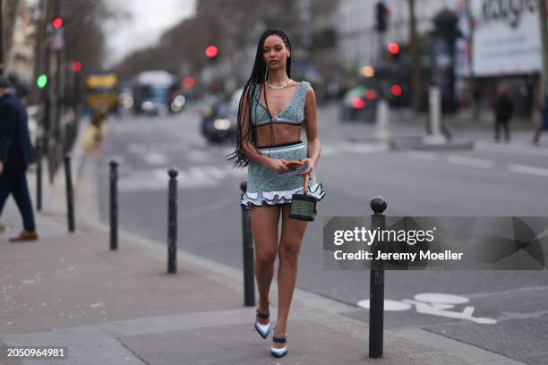 Jamilla Strand was seen wearing blue heels, a green skirt with fluffy ending as well as a cropped green top along with a green casablanca bag before...