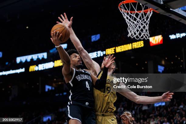 Dennis Smith Jr. #4 of the Brooklyn Nets tries to get a shot by Jakob Poeltl of the Toronto Raptors at the net in the second half of the NBA game at...