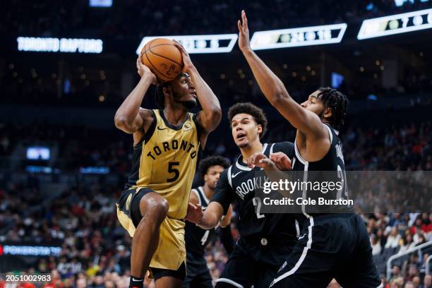 Immanuel Quickley of the Toronto Raptors puts up a shot over Cam Thomas and Cameron Johnson of the Brooklyn Nets in the first half of the NBA game at...