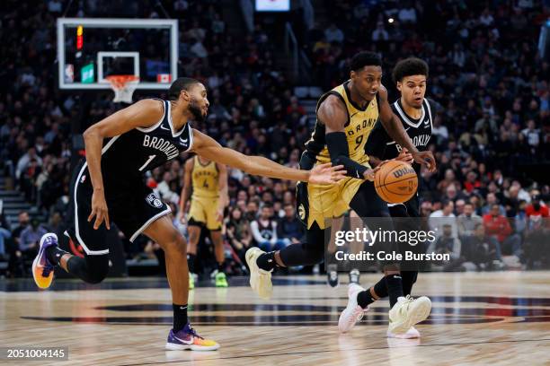 Barrett of the Toronto Raptors dribbles by Mikal Bridges of the Brooklyn Nets in the first half of the NBA game at Scotiabank Arena on February 22,...