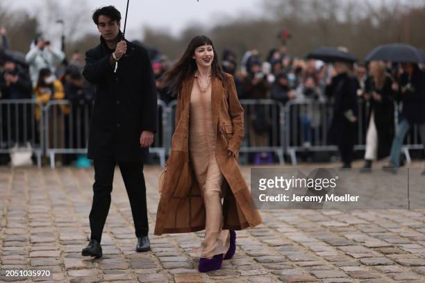 Ursula Corbero seen wearing beige sheer long dress, brown suede leather long coat, Loewe beige / brown leather bag and Loewe purple fluffy pumps /...
