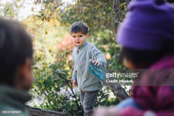 portrait of boy holding tree branch at park - stockholm park stock pictures, royalty-free photos & images