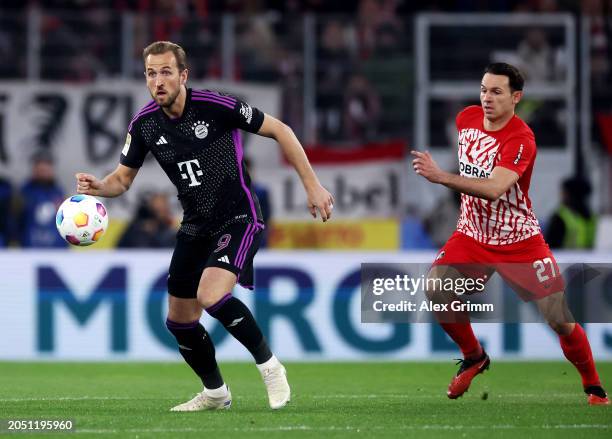 Harry Kane of Bayern Munich controls the ball whilst under pressure from Nicolas Hoefler of SC Freiburg during the Bundesliga match between...