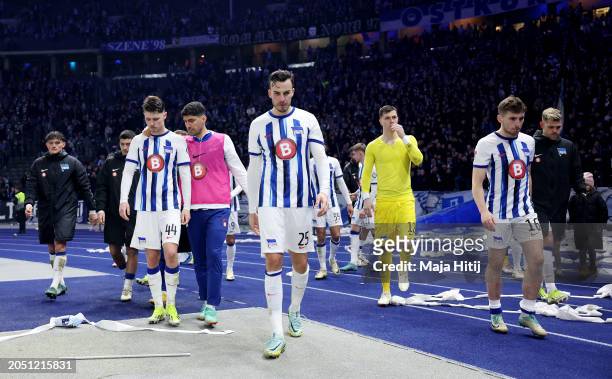 Linus Gechter, Haris Tabakovic and Jonjoe Kenny of Hertha Berlin look dejected with teammates as they leave the field after drawing with Holstein...