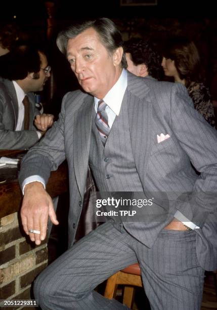 American actor Robert Mitchum holds a cigarette and sits on a barstool in New York, New York, January 1979.