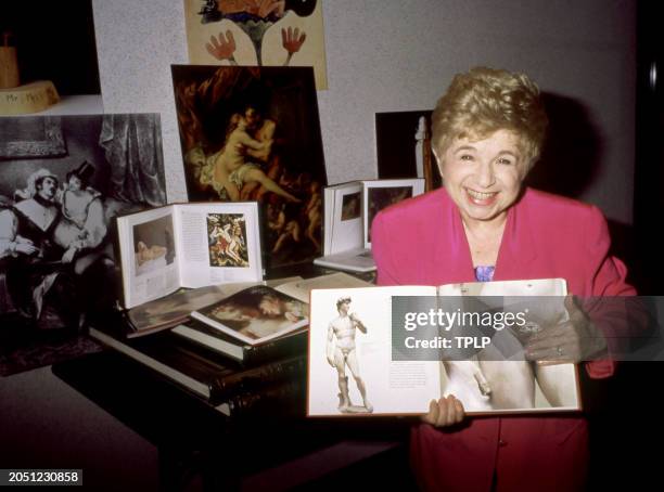 German-American sex therapist Ruth Westheimer poses for a portrait with some of her books in New York, New York, circa 1990.