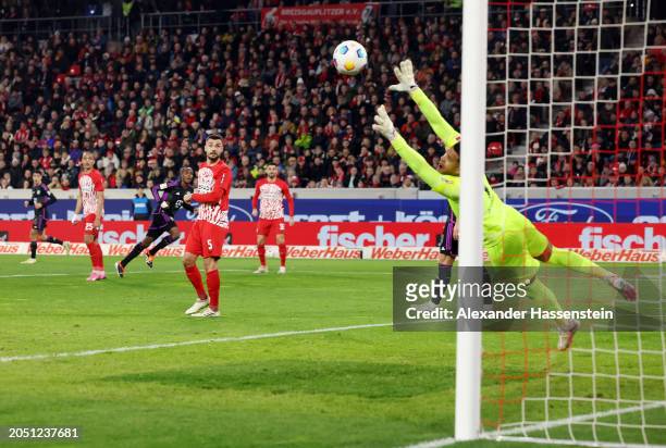 Manuel Gulde of SC Freiburg looks on as Mathys Tel of Bayern Munich scores his team's first goal as Noah Atubolu of SC Freiburg fails to make a save...