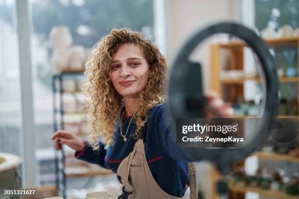donna che gira un video di marketing su opere in ceramica. - social media marketing foto e immagini stock