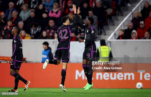 Jamal Musiala of Bayern Munich celebrates scoring his team's second goal with teammate Alphonso Davies during the Bundesliga match between Sport-Club...