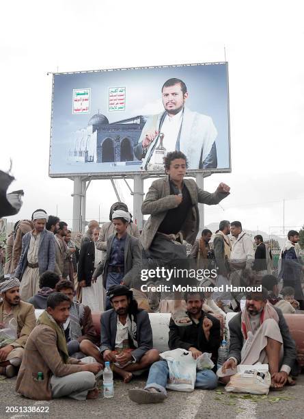 Boy jumps over Yemenis who chew Qat as they wait to participate in a protest against Israel's continuing war in the Gaza Strip, on March 1 in Sana'a,...