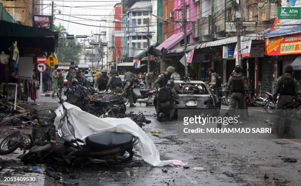 This photo taken on February 21, 2011 shows Thai bomb squad members inspecting the site of bomb attack planted by suspected separatist militants in...