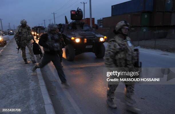 Soldiers arrive to the site of a suicide attack near Camp Phoenix in Kabul on January 26, 2010. A suicide bomber in a car laden with explosives...