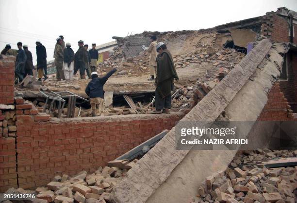 Pakistani students stand on the rubble of their destroyed school in Bara town, about 20 kilometres south of the northwestern capital Peshawar on...