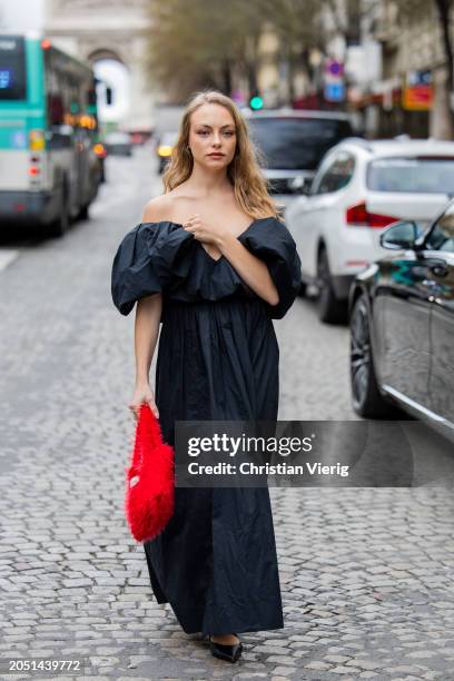 Anouchka Gauthier wears black off shoulder dress, red bag outside Nina Ricci during the Womenswear Fall/Winter 2024/2025 as part of Paris Fashion...