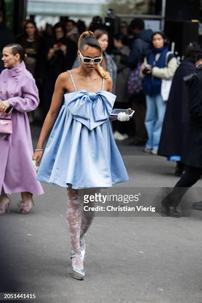 Hanna LHoumeau wears blue dress with bowknot, white tights outside Nina Ricci during the Womenswear Fall/Winter 2024/2025 as part of Paris Fashion...