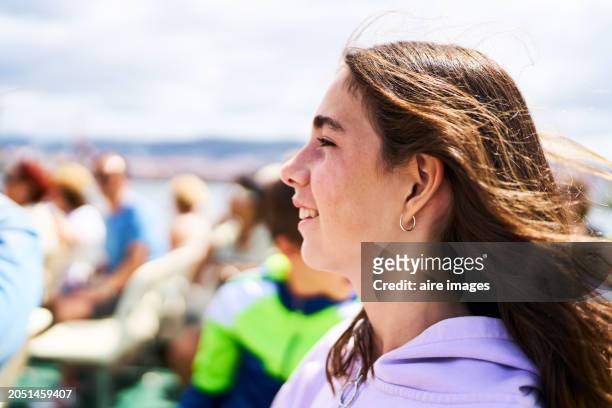 face of a tourist woman in profile in casual clothing with a group of person smiling looking away, side view - vigo stock pictures, royalty-free photos & images