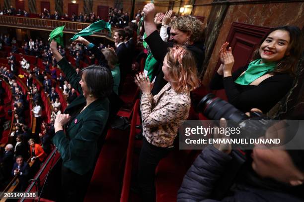 People hold green scarfs, as a symbol of the "right to abortion" after President of the National Assembly announced the result of the vote during the...