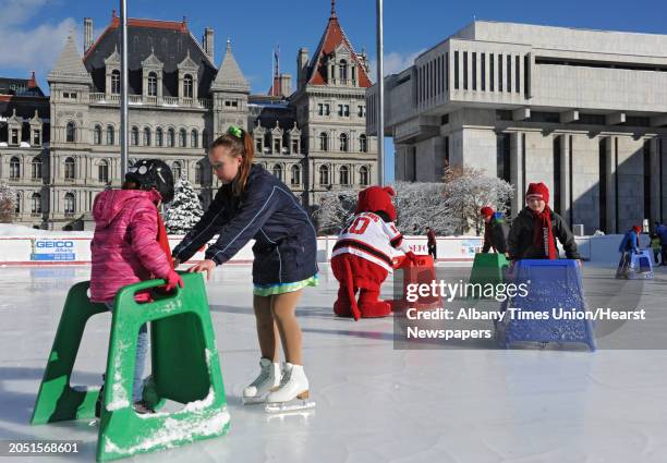 Ashley Glockler of Clifton Park, left, gets her first skating lesson from Allie Murray of Saratoga Sychronized Skating during opening day of the ice...