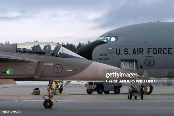 Gripen C/D fighter aircraft of the Swedish Armed Forces taxis past a US KC-135 Stratotanker military tanker aircraft at Lulea-Kallax Airport, Sweden...