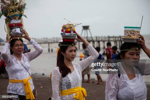 Indonesian Balinese Hindus are carrying offerings and sacred ornaments as they participate in the Melasti ceremony on Tanjung Pakis beach, Karawang,...