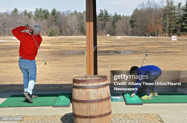 Dean Bouton of Guilderland and Rowan Healy who is up from Maryland visiting his grandparents, practice their golf swings at the Northway Golf Center...