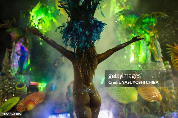 Reveller of Rosas de Ouro samba school starts dancing before participating in the opening night of parades at the Sambadrome, as part of Carnival...