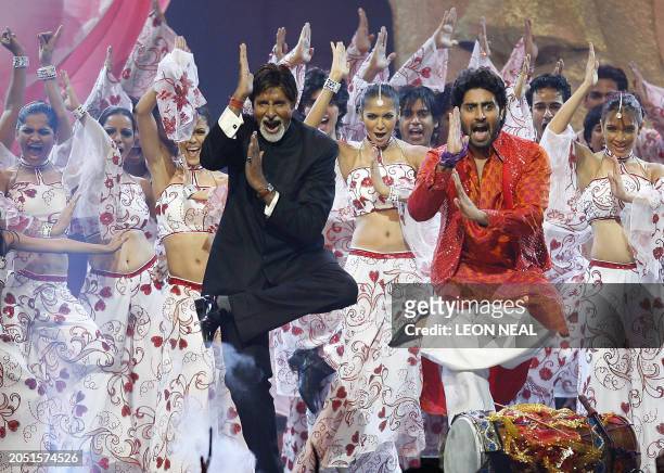 Indian actor Amitabh Bachchan and his son Abhishek Bachchan dance during the International Indian Film Academy Awards ceremony at the Hallam Arena in...