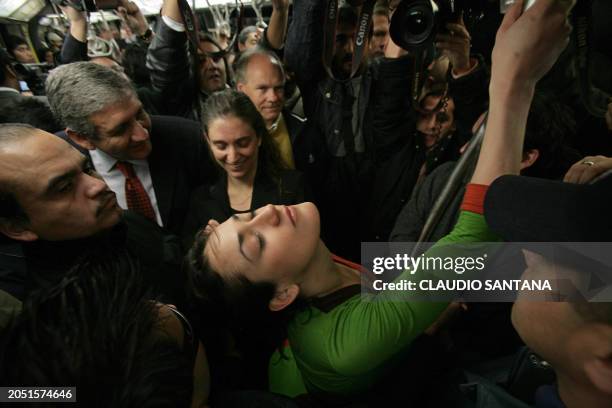 Chilean pole dancer Monserrat Morilles attempts to dance while surrounded by Santiago's subway security personnel on July 15, 2008 in Santiago....