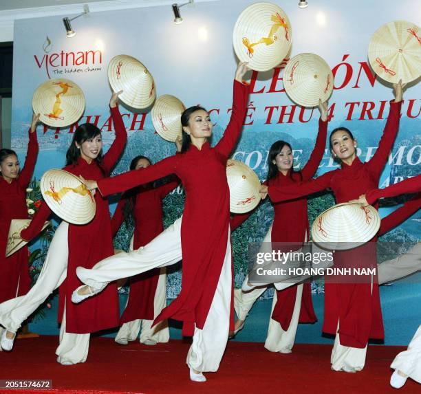 Dancers perform with traditional conical hats during a ceremony held 07 December 2007 at Hanoi airport to welcom the fourth million foreign visitor...