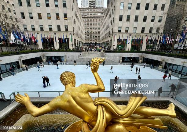 Paul Manship's gold Prometheus sculpture towers over people skating on the Rockefeller Center ice rink on March 4, 2024 in New York City.