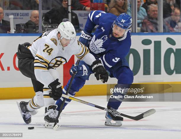 Jake DeBrusk of the Boston Bruins battles for the puck against Auston Matthews of the Toronto Maple Leafs during the second period in an NHL game at...