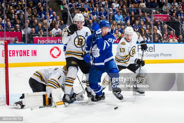 Tyler Bertuzzi of the Toronto Maple Leafs battles for the puck against Charlie McAvoy and Charlie Coyle of the Boston Bruins during the first period...