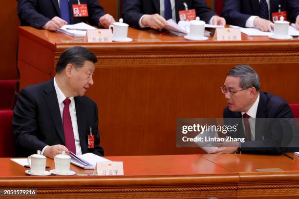 Chinese President Xi Jinping talks with Chinese Premier Li Qiang during the opening of the second session of the 14th National People's Congress at...