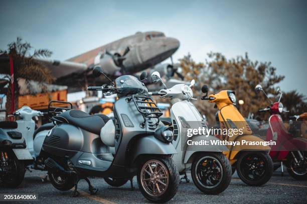 many italian vespa motor scooters parked outside at roadside - motor scooter stock pictures, royalty-free photos & images