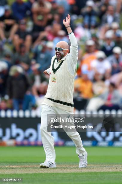 Nathan Lyon of Australia celebrates after taking the wicket of Tom Latham of New Zealand during day three of the First Test in the series between New...