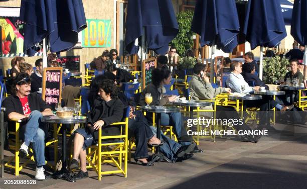 Des personnes profitent de la douceur des températures qui avoisine les 20 degés celsius, le 10 janvier 2007 à une terrasse du centre ville de...